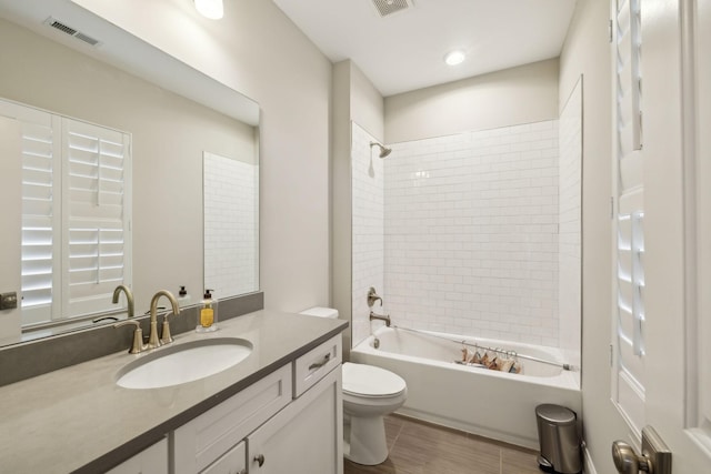 full bathroom with tiled shower / bath combo, vanity, and toilet