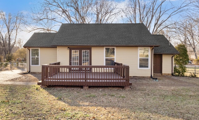 rear view of house with a wooden deck and a yard