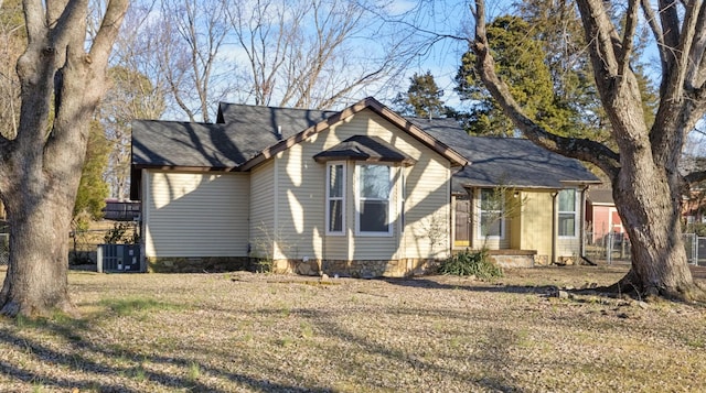 view of front of home with central AC and a front yard