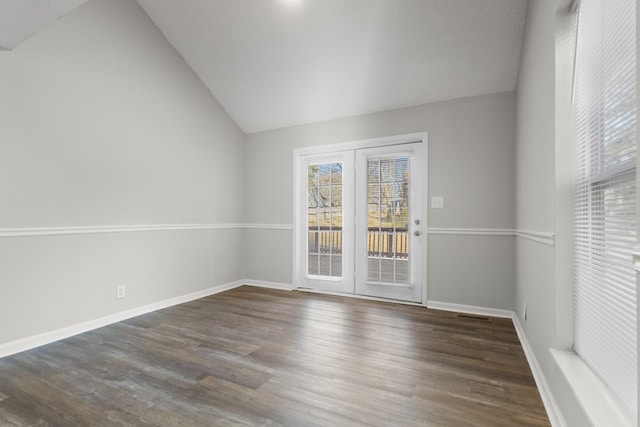 empty room featuring lofted ceiling and dark hardwood / wood-style flooring