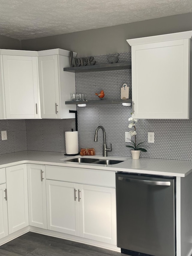 kitchen featuring dark wood-type flooring, sink, stainless steel dishwasher, decorative backsplash, and white cabinets