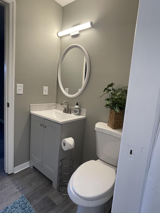 bathroom with hardwood / wood-style flooring, vanity, and toilet