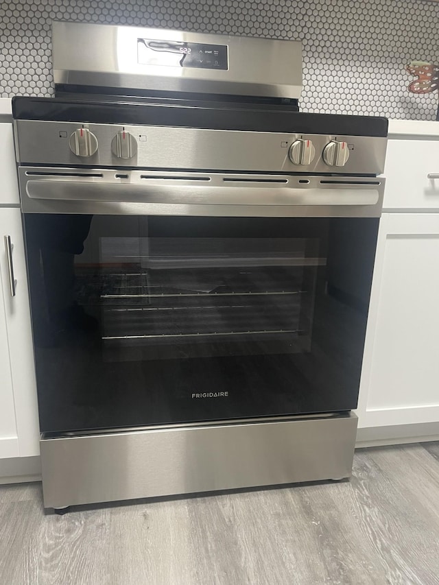 details with double oven, light hardwood / wood-style flooring, and white cabinets