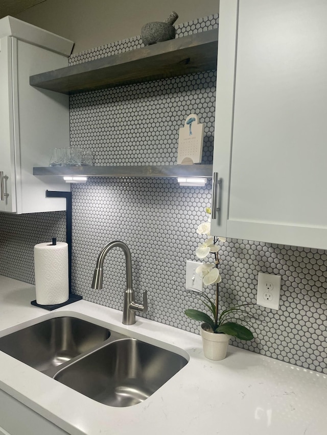 details featuring white cabinetry, sink, and decorative backsplash