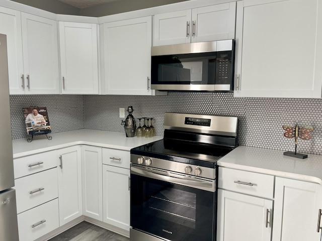 kitchen with tasteful backsplash, white cabinetry, and appliances with stainless steel finishes