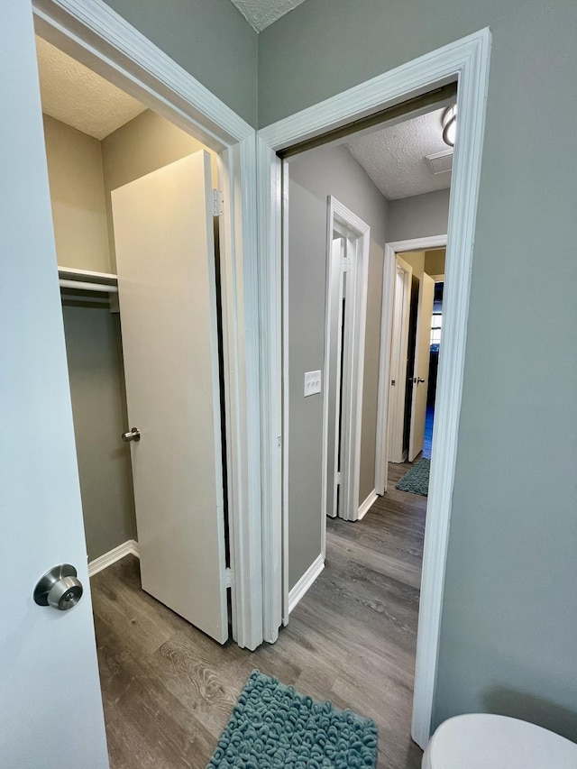 hall featuring hardwood / wood-style flooring and a textured ceiling