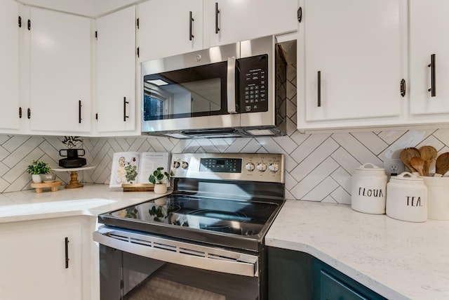 kitchen featuring stainless steel appliances, white cabinets, and backsplash