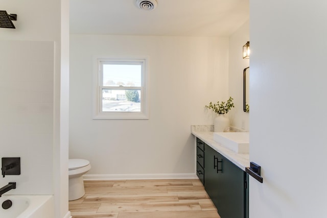 full bathroom with wood-type flooring, toilet, shower / bath combination, and vanity