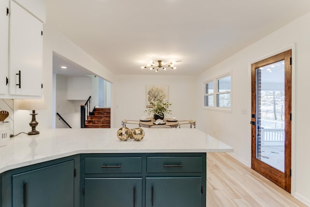 kitchen featuring a chandelier, light wood-type flooring, and kitchen peninsula