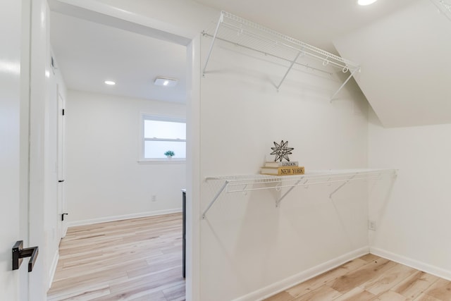 walk in closet with light hardwood / wood-style flooring