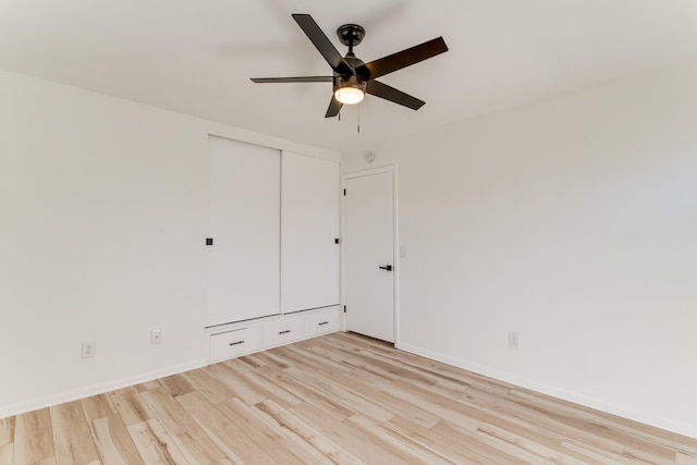 unfurnished bedroom featuring ceiling fan, a closet, and light hardwood / wood-style flooring