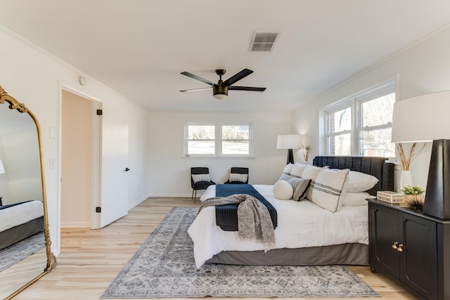 bedroom with light hardwood / wood-style flooring, ornamental molding, and ceiling fan