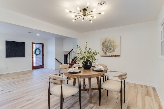 dining space featuring a notable chandelier and light wood-type flooring