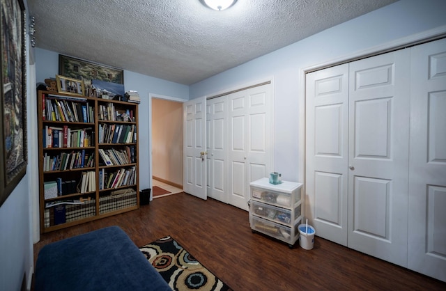 living area featuring dark wood-type flooring and a textured ceiling