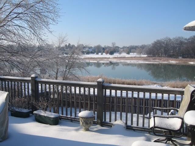 snow covered deck featuring a water view