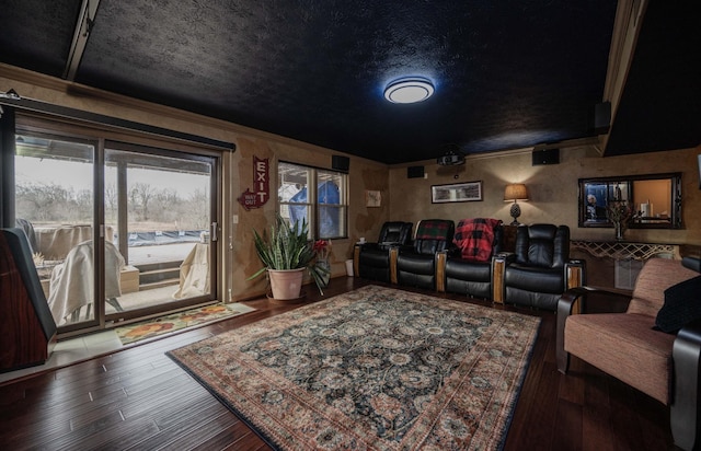 home theater room with crown molding, hardwood / wood-style floors, and a textured ceiling