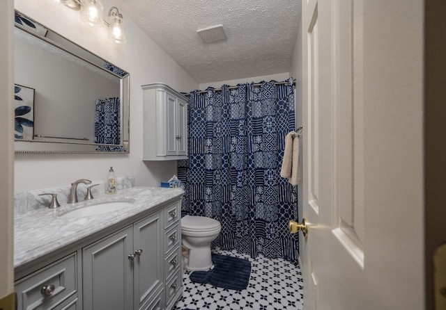 bathroom featuring walk in shower, toilet, a textured ceiling, vanity, and tile patterned flooring