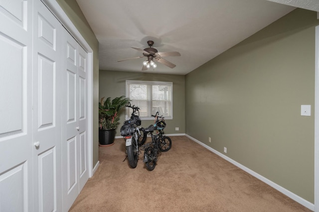 workout area with ceiling fan and light colored carpet