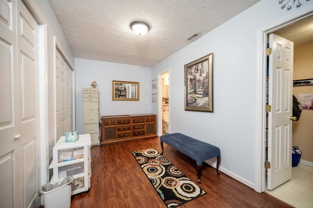 hall with hardwood / wood-style floors and a textured ceiling