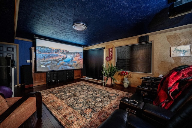 cinema room featuring ornamental molding, wood-type flooring, and a textured ceiling