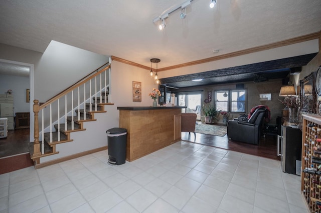 interior space with crown molding, rail lighting, and a textured ceiling