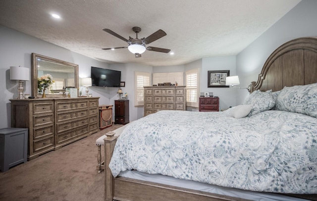 carpeted bedroom with ceiling fan and a textured ceiling