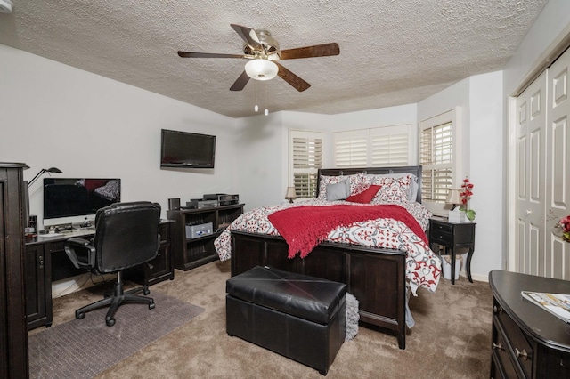 bedroom with light carpet, ceiling fan, a closet, and a textured ceiling