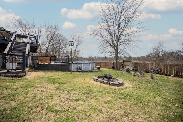 view of yard featuring a swimming pool side deck and a fire pit