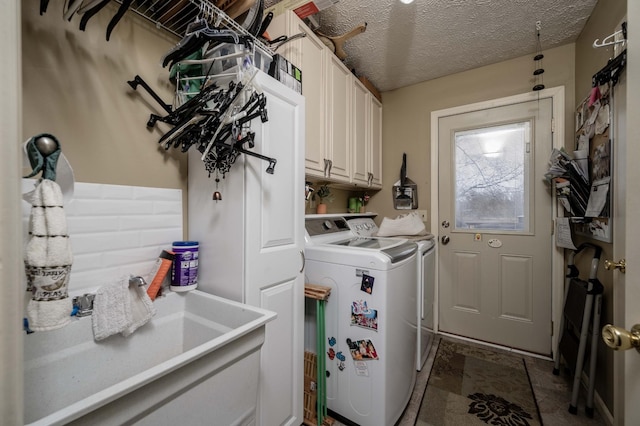 laundry area with cabinets, sink, washing machine and dryer, and a textured ceiling