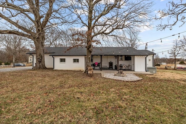 rear view of house featuring a patio, central air condition unit, and a lawn