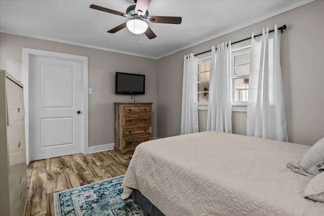 bedroom featuring wood-type flooring, ornamental molding, and ceiling fan