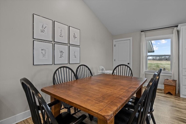 dining area with lofted ceiling and light hardwood / wood-style flooring