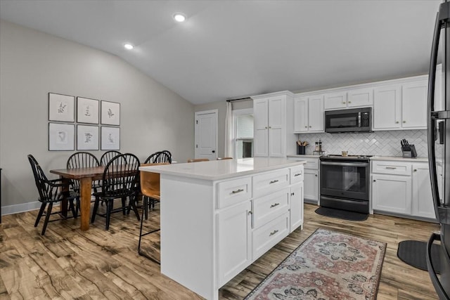 kitchen featuring white cabinetry, a center island, and electric range