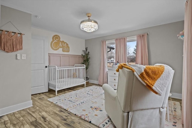 bedroom featuring a nursery area and light hardwood / wood-style flooring