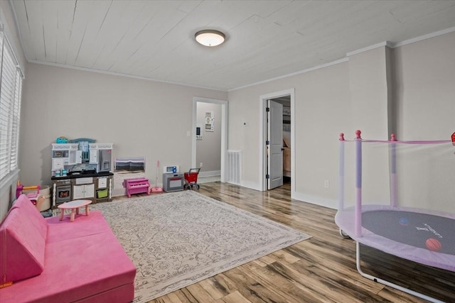 recreation room featuring hardwood / wood-style flooring and ornamental molding