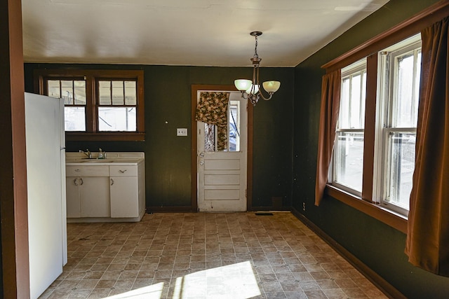 unfurnished dining area with an inviting chandelier and sink