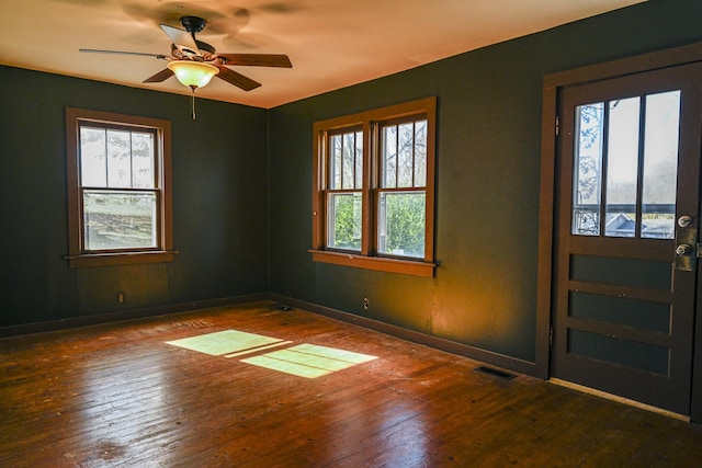 empty room featuring dark wood-type flooring and ceiling fan