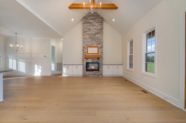 unfurnished living room featuring a fireplace, a chandelier, high vaulted ceiling, light hardwood / wood-style flooring, and beam ceiling