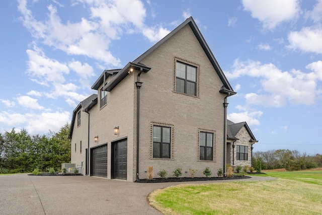 view of home's exterior featuring a garage, a yard, and central AC unit