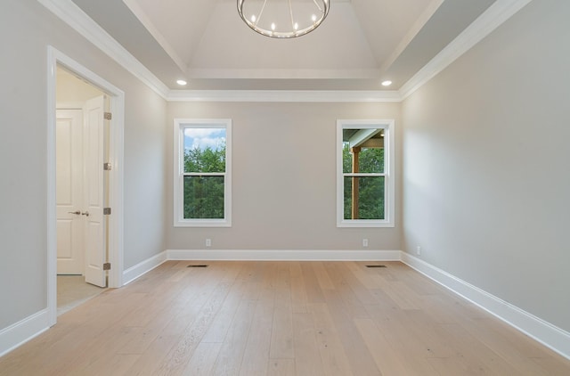 spare room featuring an inviting chandelier, lofted ceiling, and light wood-type flooring