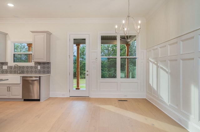 interior space with ornamental molding, sink, a chandelier, and light hardwood / wood-style floors