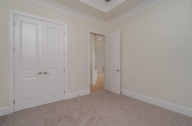 unfurnished bedroom featuring crown molding, carpet flooring, and a closet