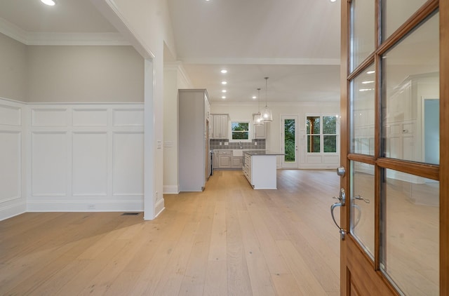 interior space featuring crown molding, sink, and light hardwood / wood-style floors