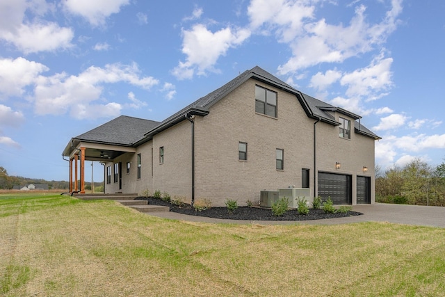 view of side of home with a garage, a porch, central AC unit, and a lawn