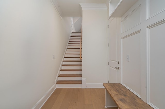 staircase with crown molding and hardwood / wood-style flooring