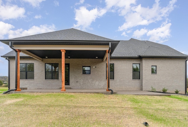 back of house featuring a lawn and a patio