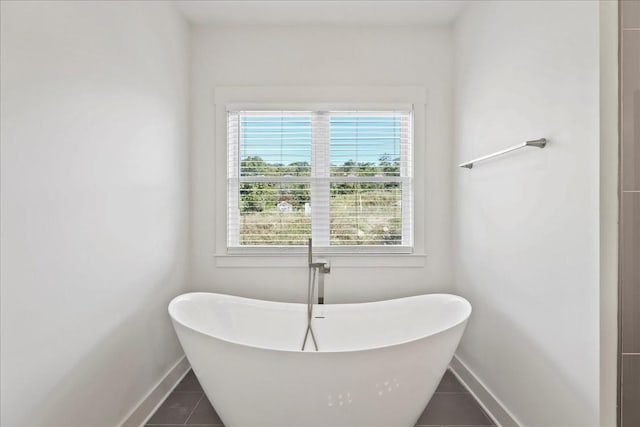 bathroom with a bath and tile patterned floors