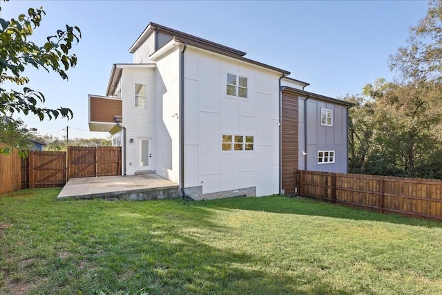 rear view of property featuring a yard and a patio area