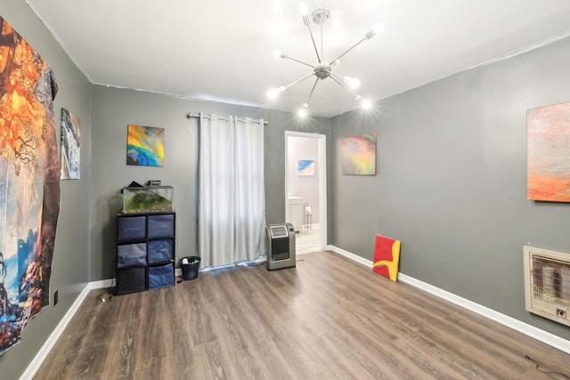 miscellaneous room with hardwood / wood-style flooring, a chandelier, and heating unit