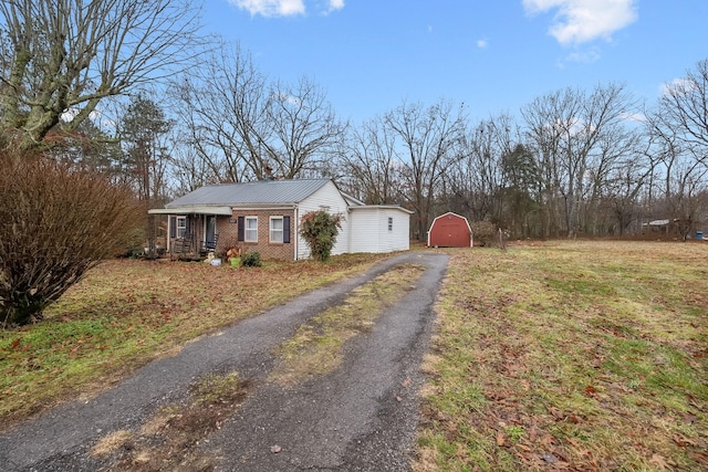 view of side of property with a porch and a storage unit